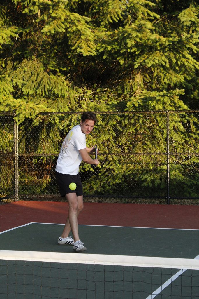 A pickleball player mid-swing on court